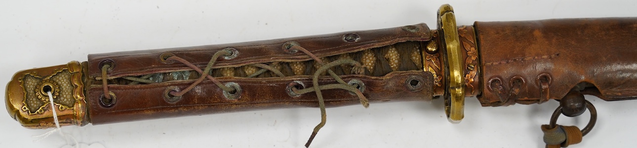A Japanese WWII army officer’s sword Katana, blade 57.9cm, signed and dated with Seki Arsenal stamp, retaining good polish, in shin gunto mounts with leather combat cover on hilt and scabbard, the latter with plate stamp